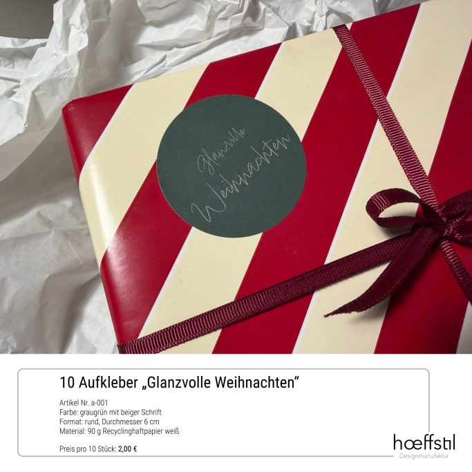 Rotes Geschenk mit weißen Streifen, grünem Aufkleber und lila Schleife.