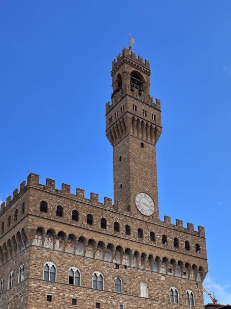 Der Palazzo Vecchio in Florenz mit markantem Turm und blauem Himmel.