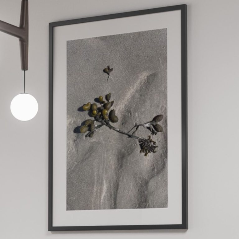 Schwarzer Tisch mit zwei Stühlen und einer gerahmten Momentaufnahme an der Wand.